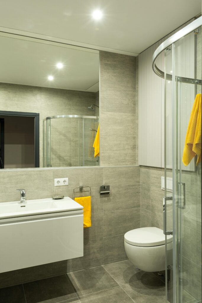 Baño minimalista reformado con mampara negra y ducha moderna