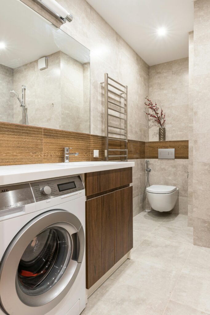 Baño moderno reformado con mueble de madera, lavadora integrada y acabados porcelánicos